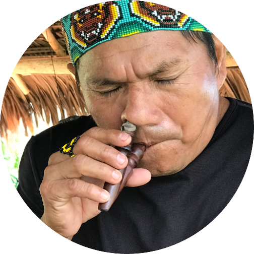 A Huni Kuin man taking hapé with a kuripe, eyes closed