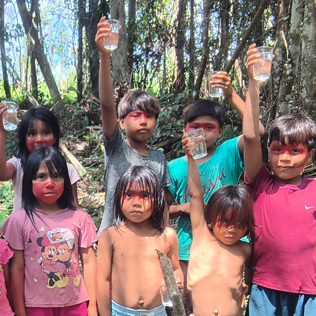 Noke Koi children holding up glasses of clean water in the forest