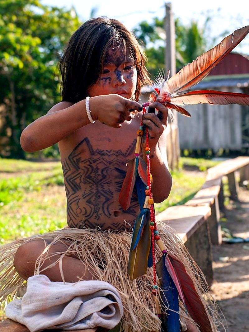 A young Yawanawá girl adjusts her feathered headdress during the yearly festival